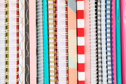Stack of colorful books and copybooks as background, closeup