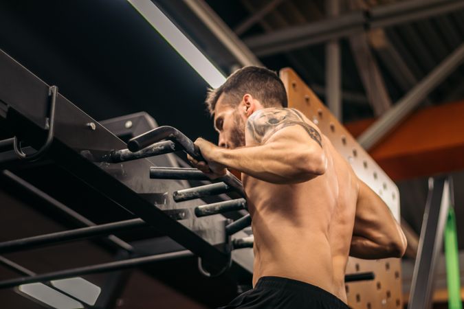 male athlete doing muscle ups in a gym