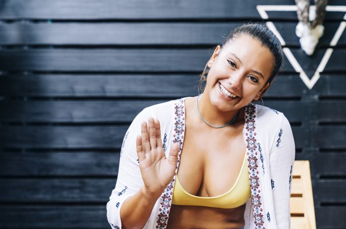 Woman smiling and waiving to the camerahair