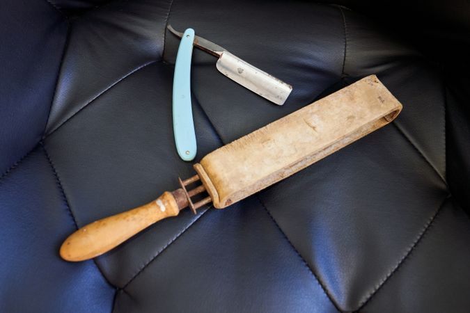 Old fashioned razor with razor strop on couch