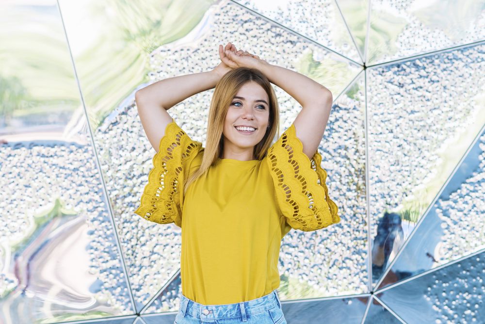 Young cheerful woman posing with hand in air