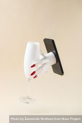 Woman’s hand reaching out of phone holding champagne glass 0y7ra4
