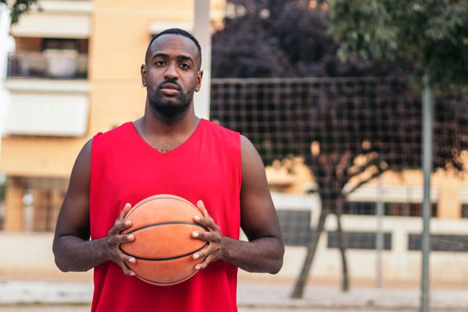 Confident Basketball Player Holding Ball with Determination