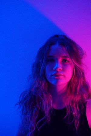 Portrait of adolescent girl in purple lit studio