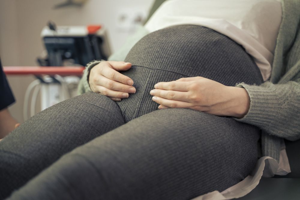 Close-up of a pregnant woman's belly in a medical clinic.