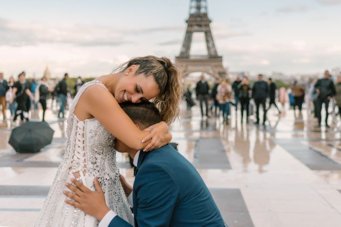 Bridegroom kneeling and kissing bride