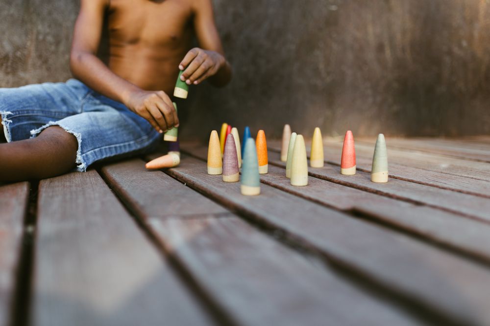 Crop Black kid playing with cones