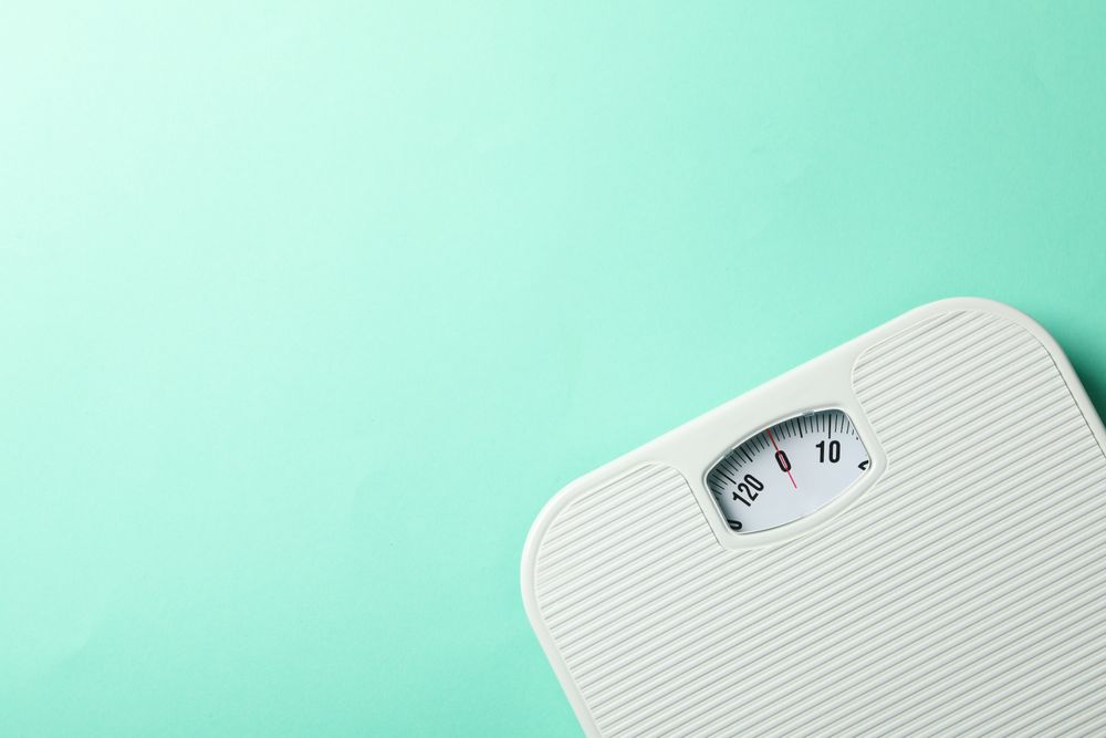 weight scales on mint background. Weight loss concept