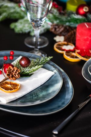 Navy Christmas table setting with decorative berries and dried orange slice