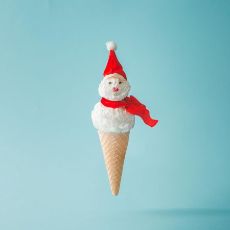 Snowman made of ice cream on bright blue background