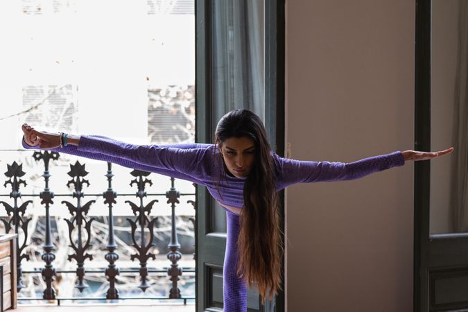 Woman stretching legs while practicing yoga at home