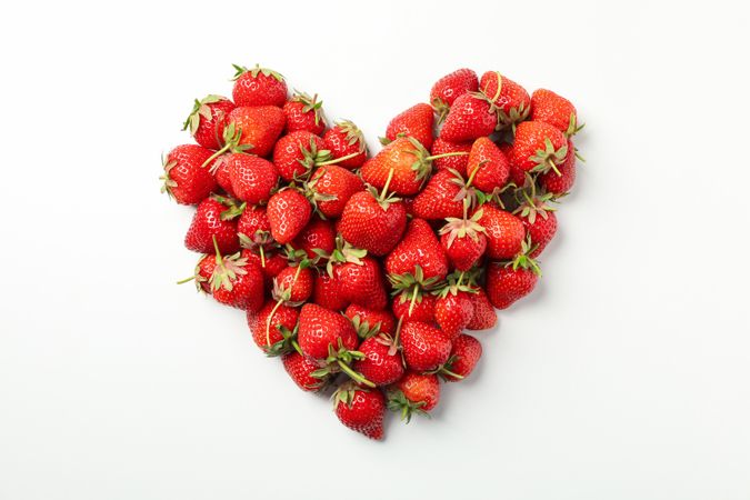 Heart made of tasty strawberry on neutral background, top view. Summer berry