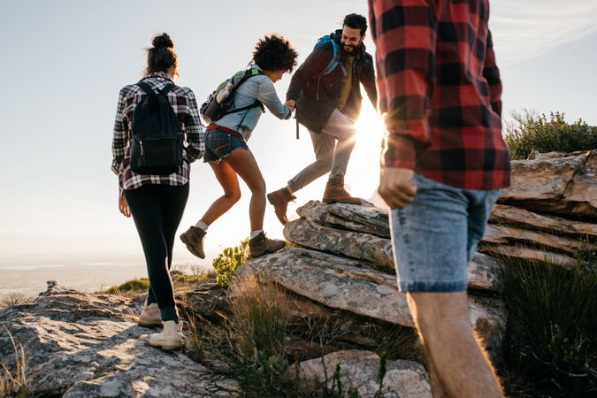 Group of hikers with backpacks hiking up mountain