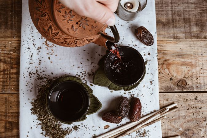 Aromatic tea dates and clay teapot on table