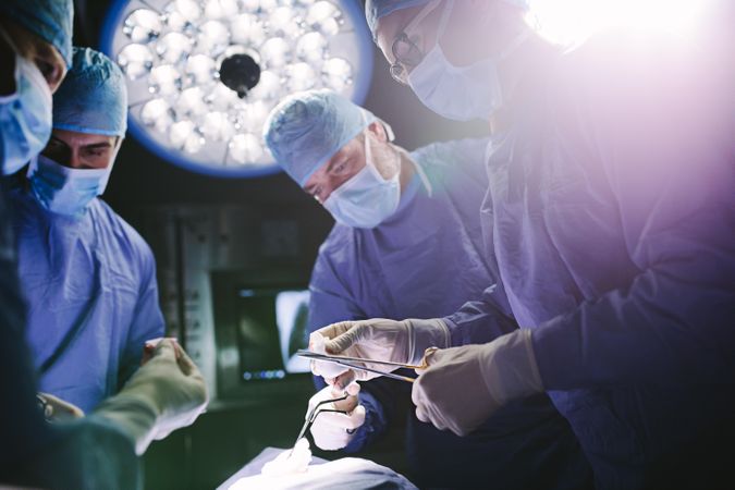 Team of doctors performing surgical procedure in operating theater