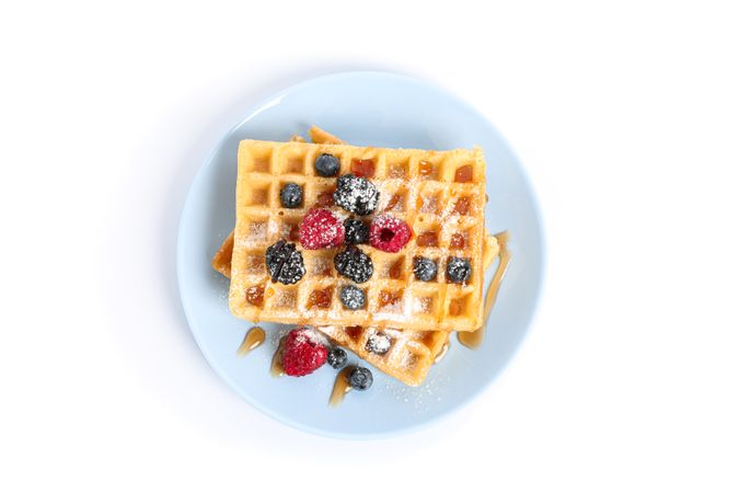 Waffles with berries on plate isolated on blank background