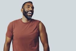 Man smiling and looking off with bandaid on arm, copy space