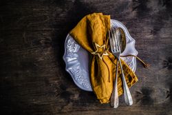 Table setting with heart ornament and mustard colored napkin