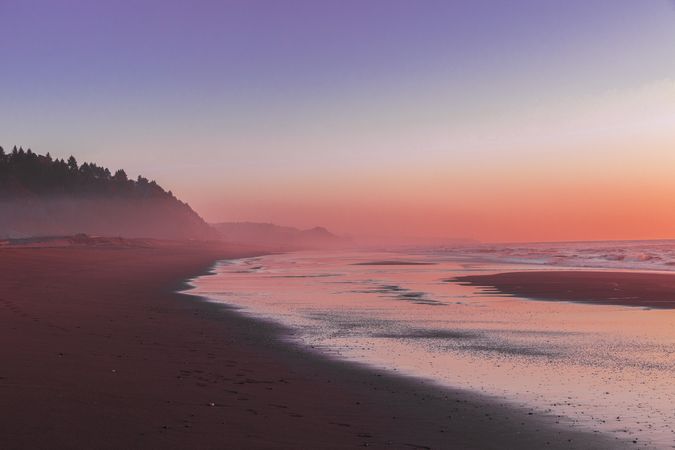 Calm misty coast during a colorful sunset