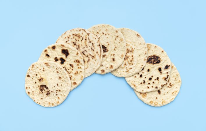 Naan bread pile on a blue table, top view