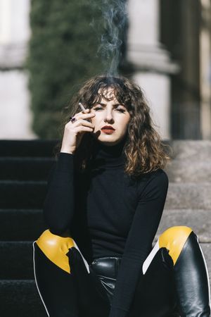 Trendy woman smoking on street