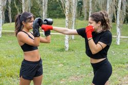 Female boxers training boxing sparring and punching  outdoors