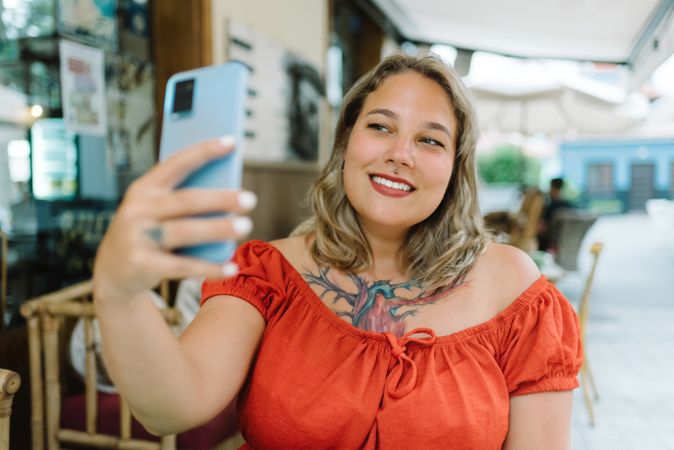 Smiling woman taking selfie on smartphone outdoors
