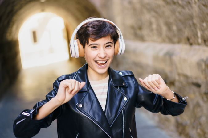 Joyful and energetic youth are dancing, wearing headphones, in a lively urban environment