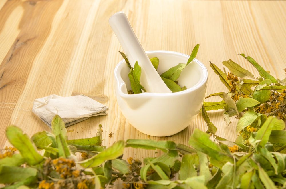 Tea bags and linden blossoms grinded in a mortar