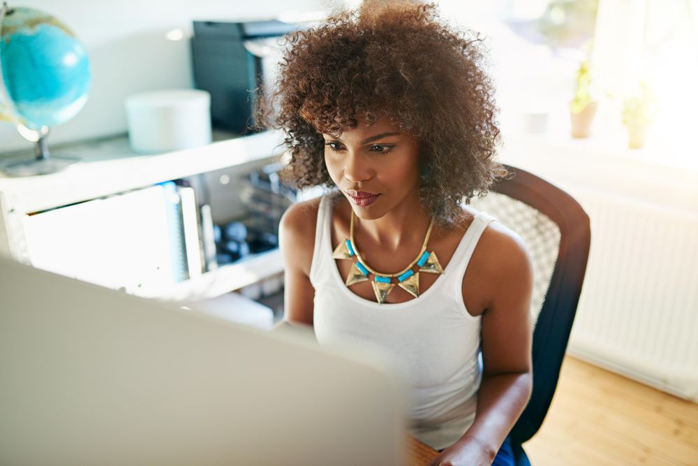 Female entrepreneur in bright office concentrating as she works in the morning