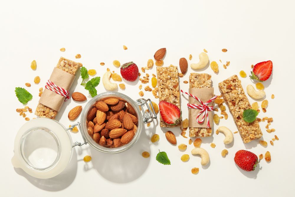 Granola bars, strawberry and almond on blank background, top view