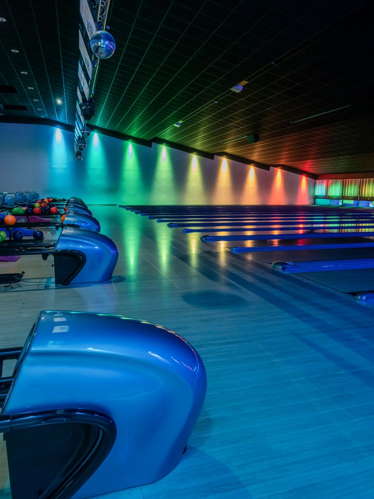 Multi-colored illumination of lanes in a huge bowling alley.