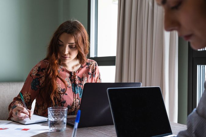 Positive colleagues working on laptop in light workspace
