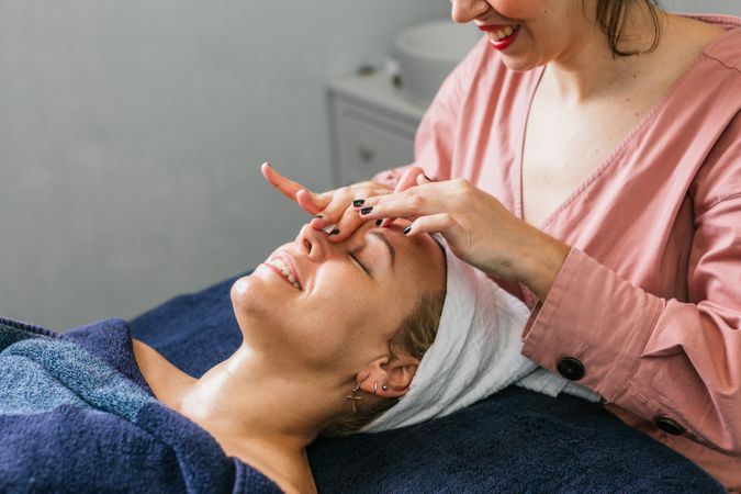 Anonymous masseuse doing massage for woman in spa salon