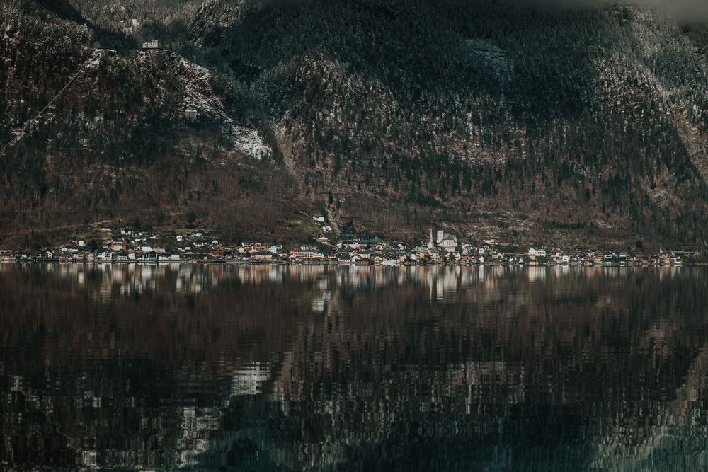 Crystal lake reflecting dark mountain and shore