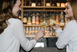 Cheerful woman drinking cocktails in bar