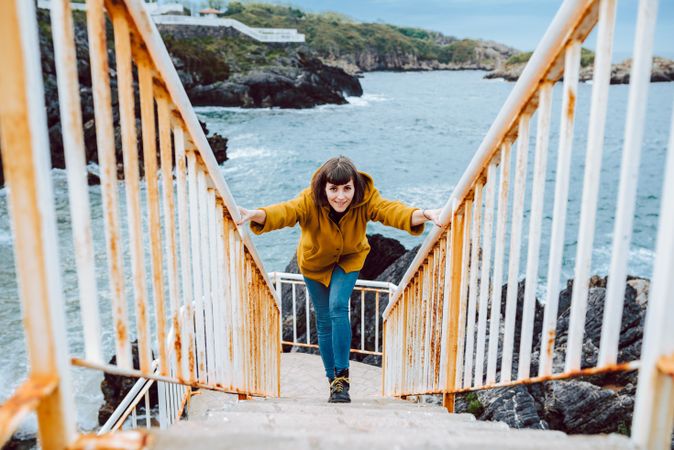 Woman standing on steps near sea