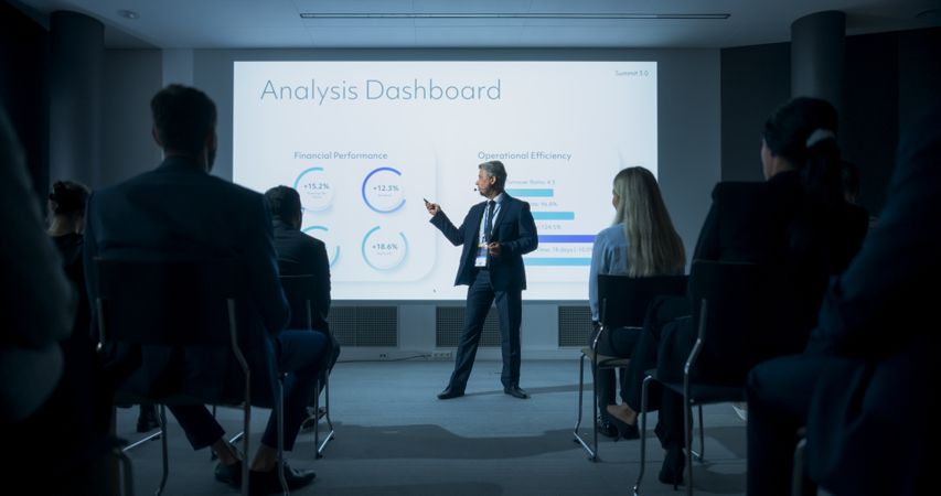White Male CEO Giving Presentation to Diverse Audience of Businesspeople At International Business Conference.