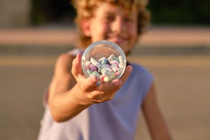 Child with pile of chalks in jar