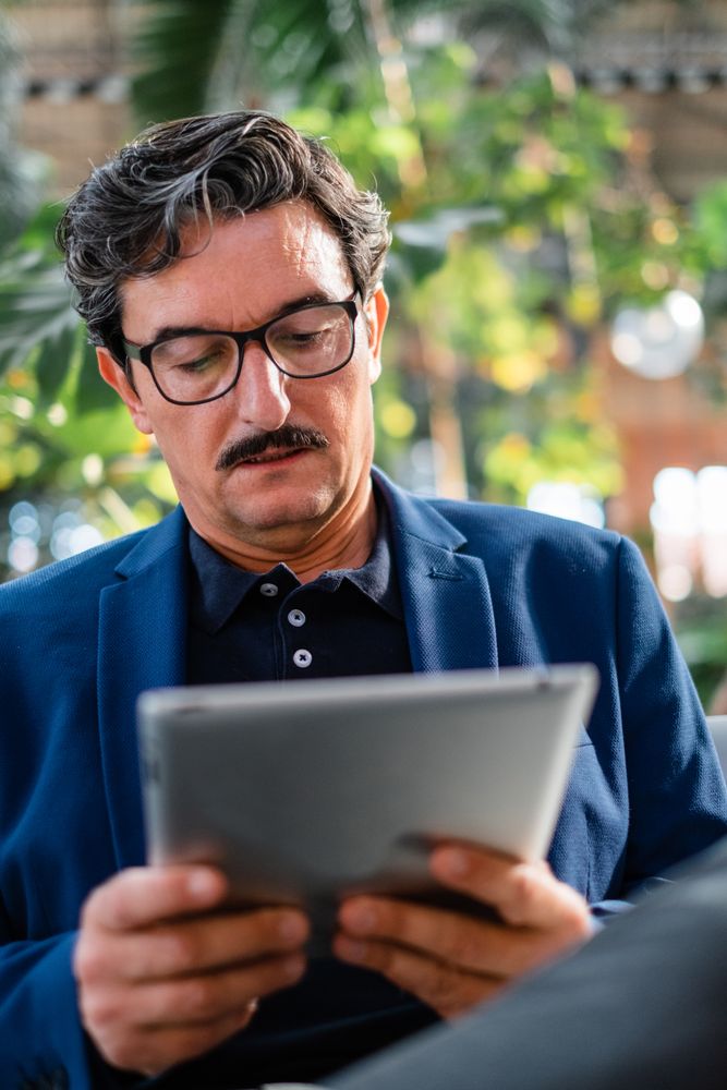 Mature handsome man using digital tablet outdoors