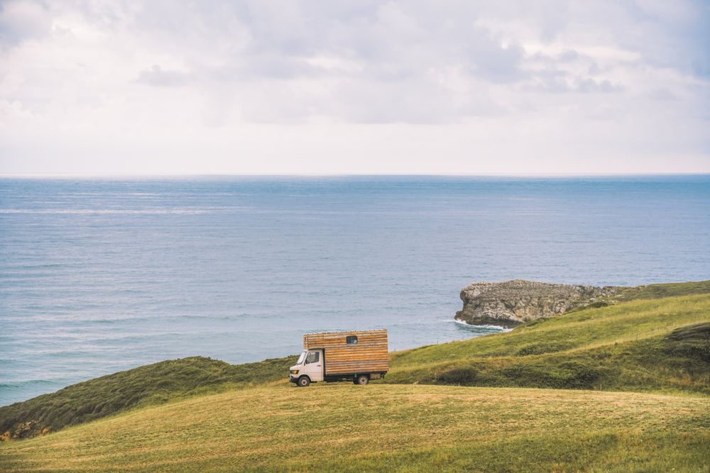 Landscape of empty meadow with passing truck near seaside