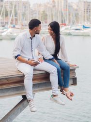 Man and woman sitting on dock with feet