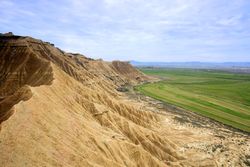 Stone desert hills near green field