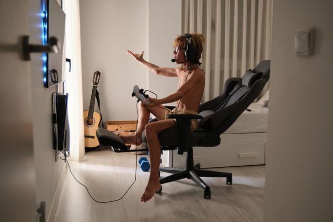 Concentrated happy young man sitting playing games