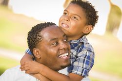 Father and Son Playing Piggyback in a Sunny Park