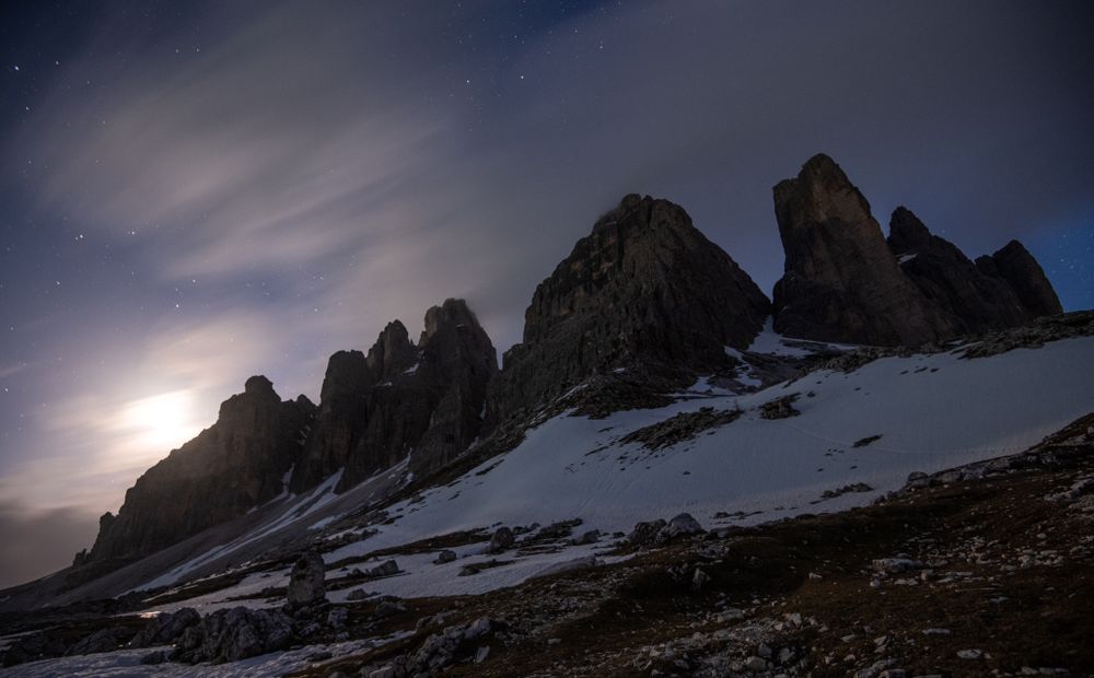 Dark mountains on white plain under starry sky