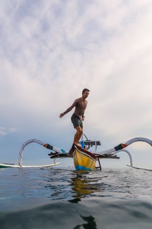 Man diving from boat in waving water