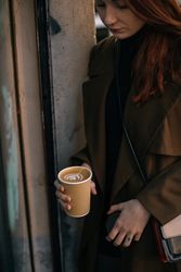 Female leaving cafe with to go coffee
