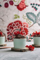 Three Chocolate cakes in the cup with currants and sugar glass.