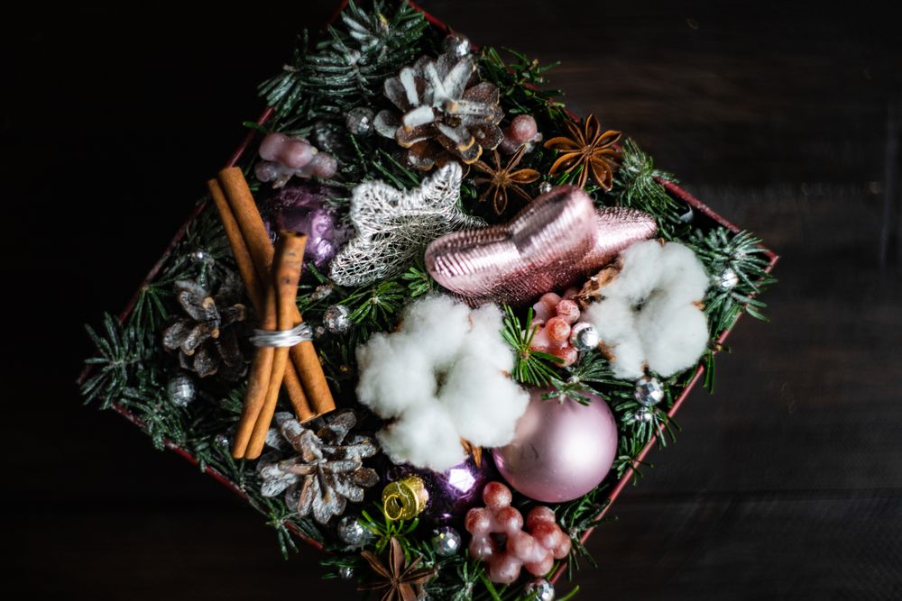 Top view of box of Christmas decorations with baubles, fir tree and cotton heads